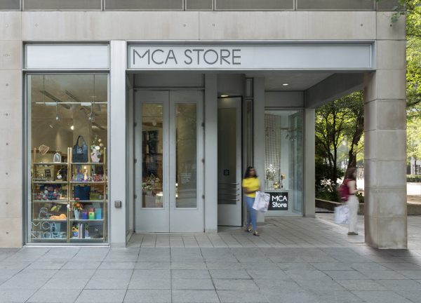 The exterior of the MCA Store with two shoppers exiting with bags