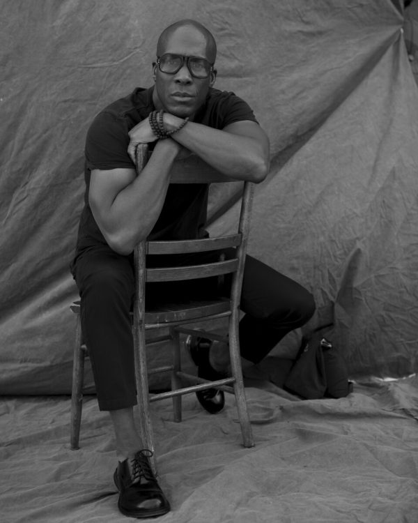 Black and white portrait of Marquise Stillwell sitting on a backwards chair