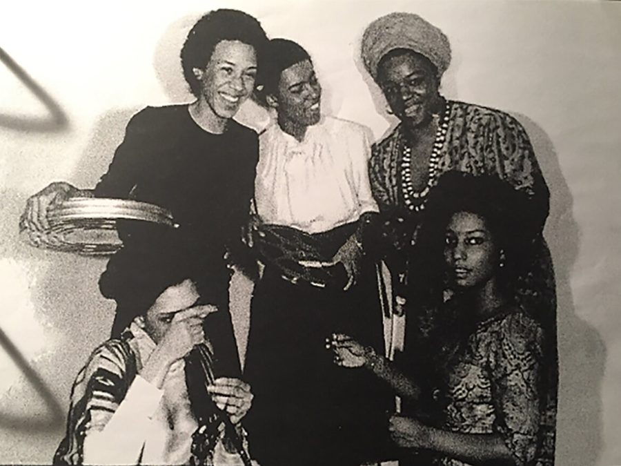 Black-and-white archival photograph of five women arranged in a semi-circle holding film and film canisters.