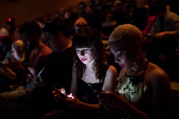 Photo of two people looking at their phones.