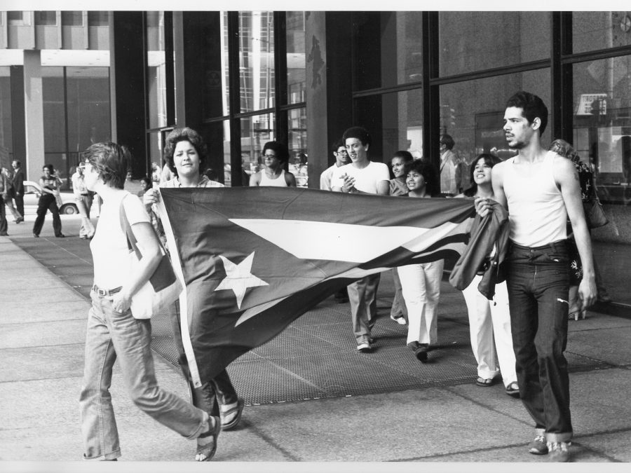 Black-and-white photo of a group of people carrying the Puerto Rican flag.