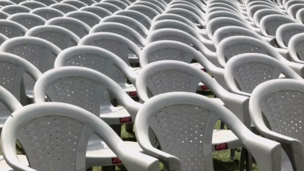 Lines of gray plastic lawn chairs fill the frame.