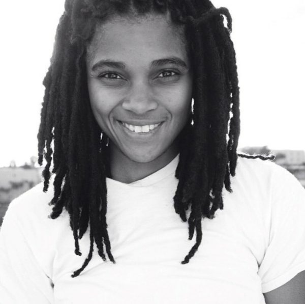 Black and white portrait of a person with medium-length dreadlocks