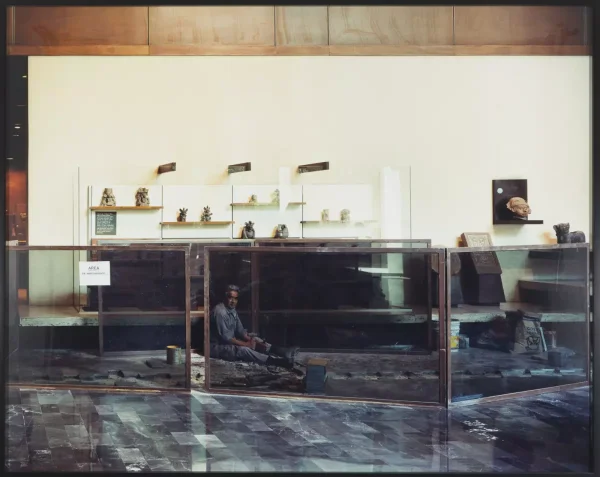 A worker is on display behind a glass barrier as he installs marble tiles