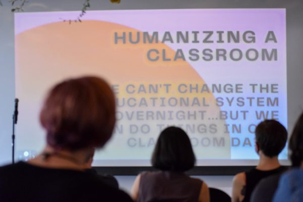 Attendees look up at a slideshow being presented with 