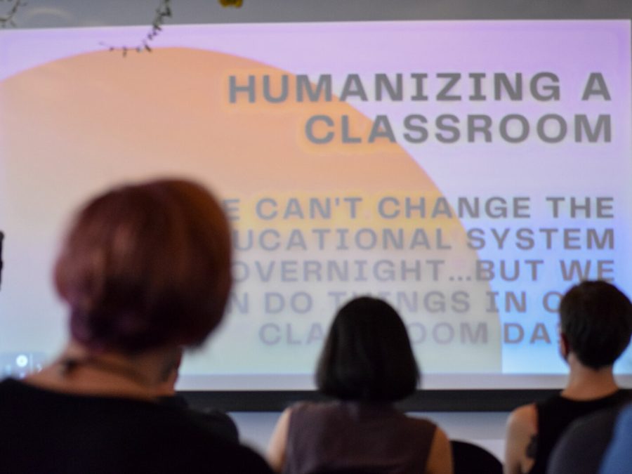 Attendees look up at a slideshow being presented with 