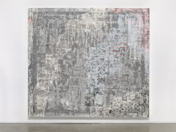 A mostly black and white abstract square painting hung on a white wall