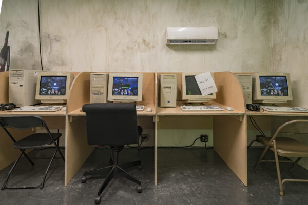 Four work areas set up with old computers at each. The computer second from the right has a paper taped over the screen