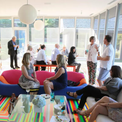 A group of people gather in a bright, window-filled space.