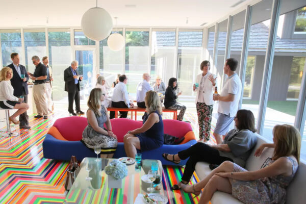 A group of people gather in a bright, window-filled space.