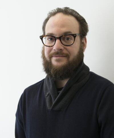 A portrait of a bearded man with glasses