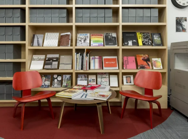 Photo of two chairs and a coffee table in front of a bookshelf.