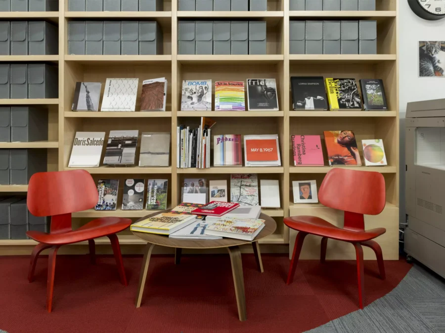 Photo of two chairs and a coffee table in front of a bookshelf.