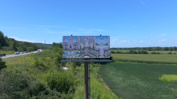 A billboard between a highway and a field