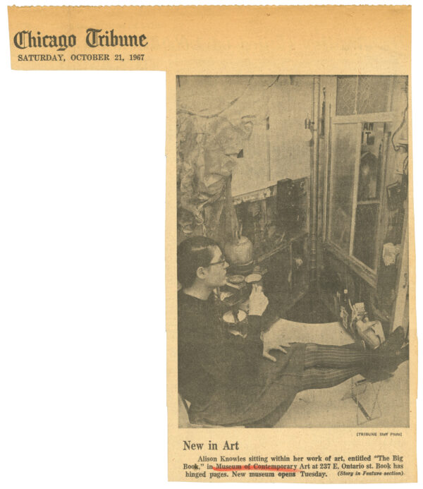 A yellowed cut out from the Chicago Tribune of an image of a person sitting on the floor holding a coffee mug amongst a lot of various objects.