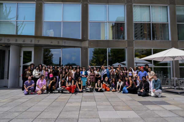 A group of people pose in front of the Museum of Contemporary Art Chicago.