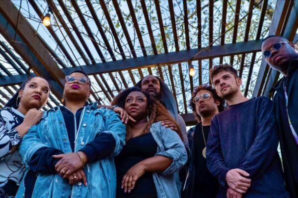 A seven-person band photo taken from the ground up
