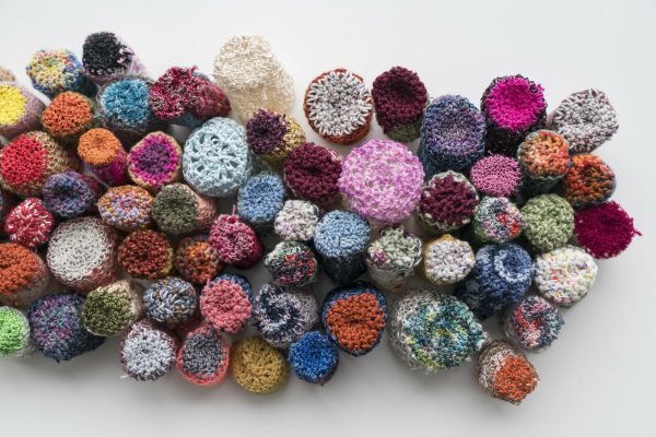 Balls of yarn in various, bold colors assembled close together in an amorphous cloud-like mass.