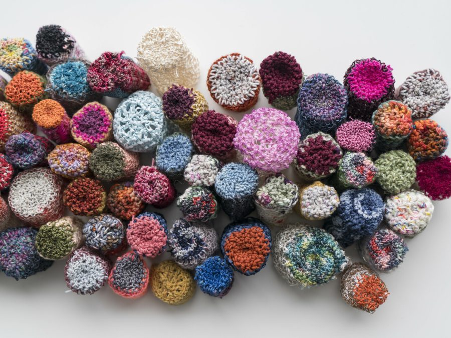 Balls of yarn in various, bold colors assembled close together in an amorphous cloud-like mass.