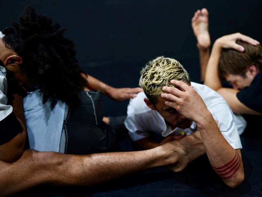 A group of people entwined with each other with their heads down