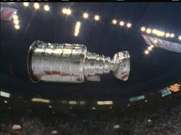 The Stanley Cup floating in the middle of an arena filled with lights