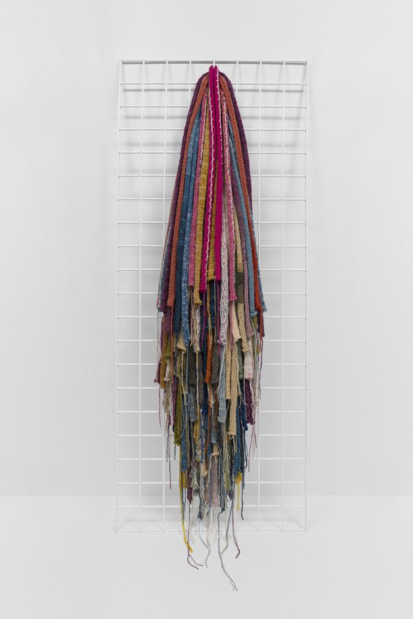 Various colored ropes hang like a horse's tail from a white grid