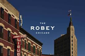 Street view of older Chicago buildings with a white text overlay reading The Robey Chicago