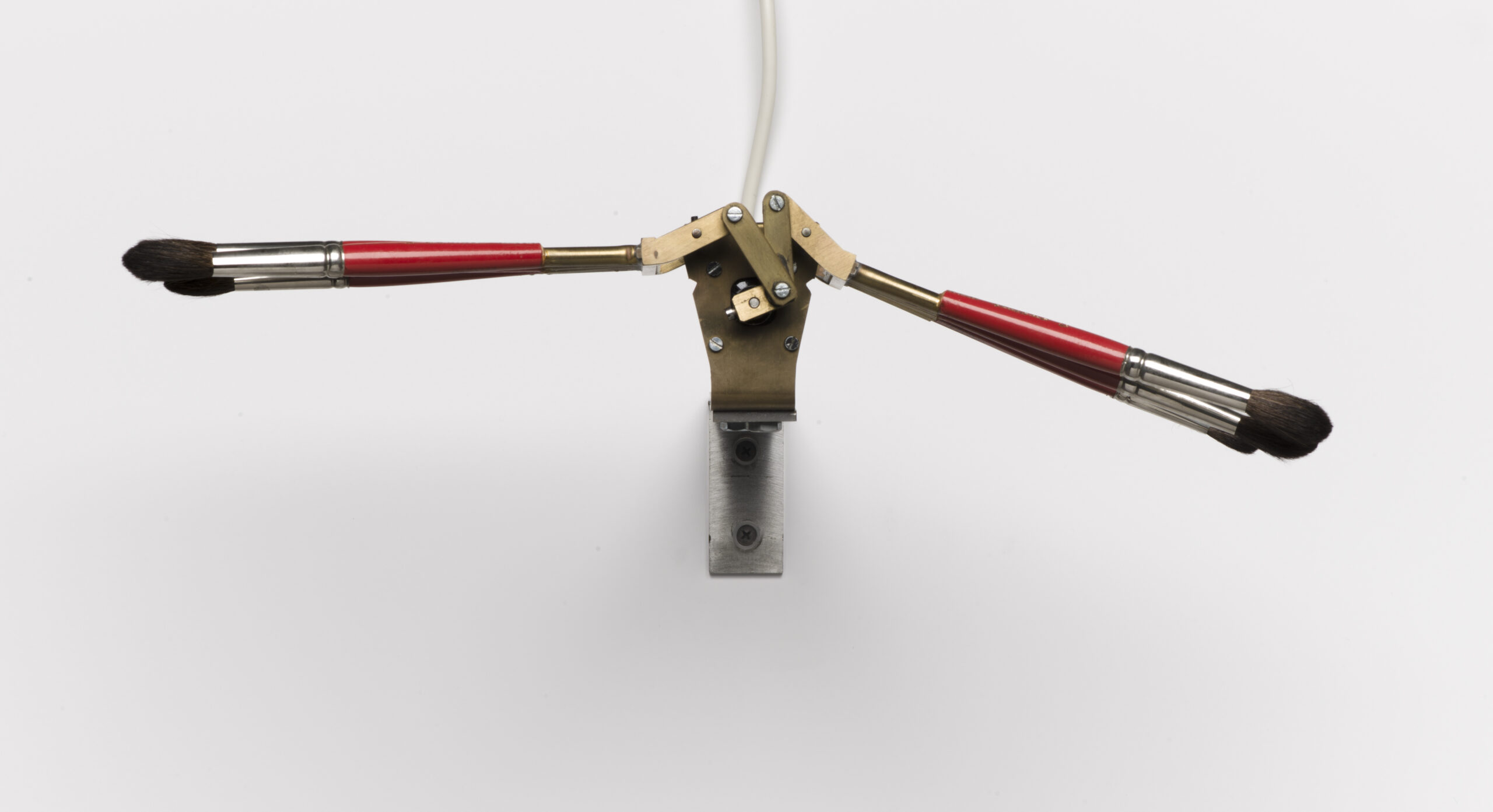 An electronic contraption holding three paintbrushes on each side giving the illusion of wings
