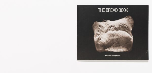 The front of a book featuring the end of a piece of bread against a black background. White text above the bread reads The Bread Book; and below the bread, Kenneth Josephson.
