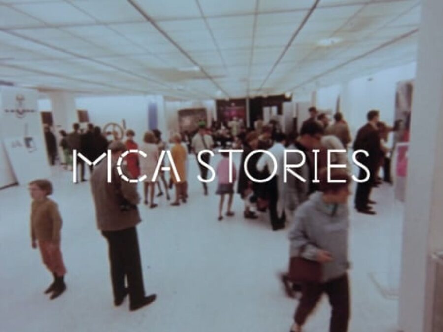 An archival photo of a gallery full of people with white text over it reading MCA Stories