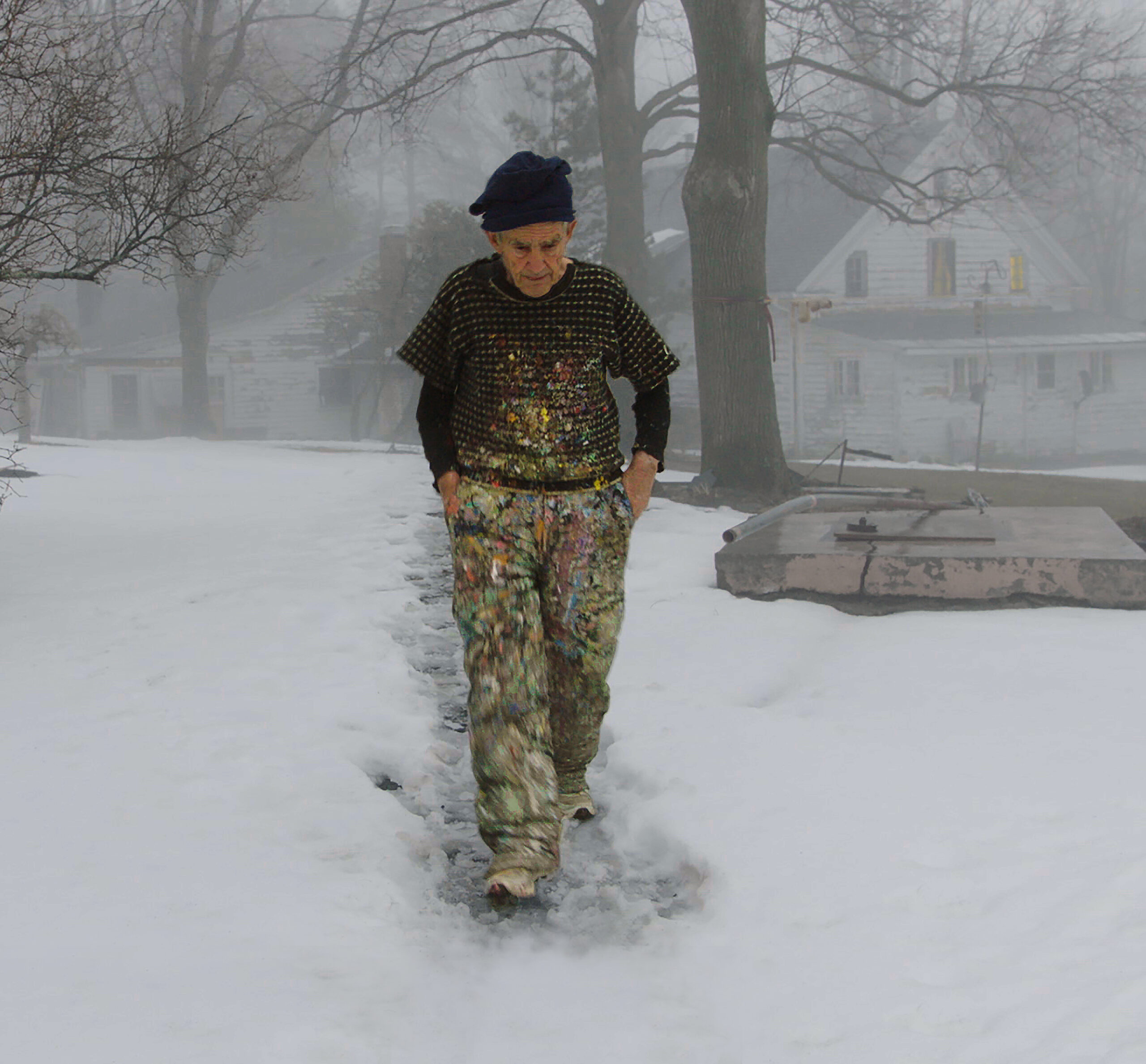 A solitary man walking through a snowy landscape