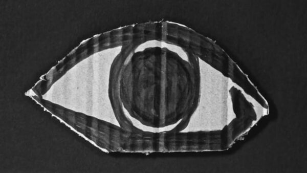An eye painted on a piece of cardboard against a black background