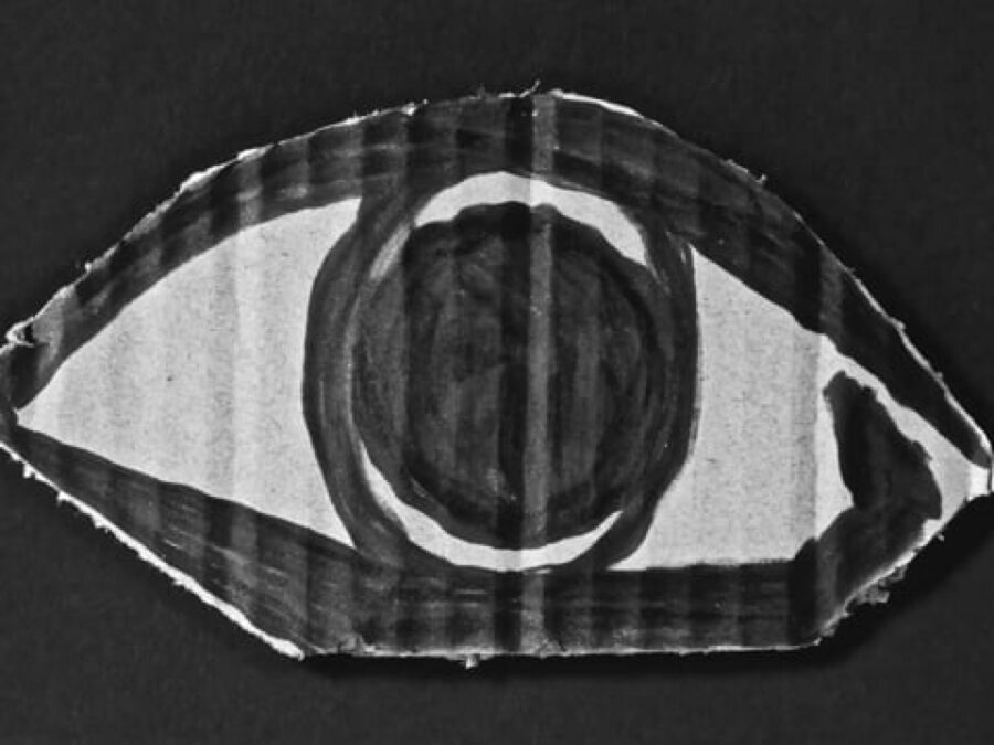 An eye painted on a piece of cardboard against a black background