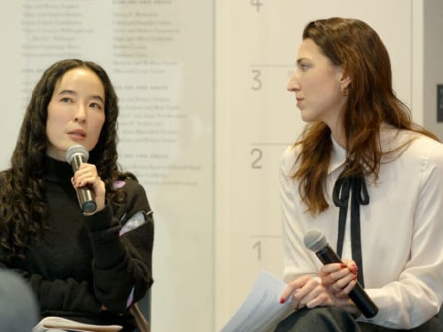 Two female-presenting people holding microphones