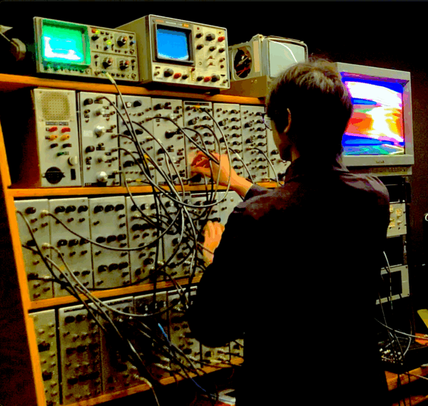 A person working on a computer system with lots of wiring