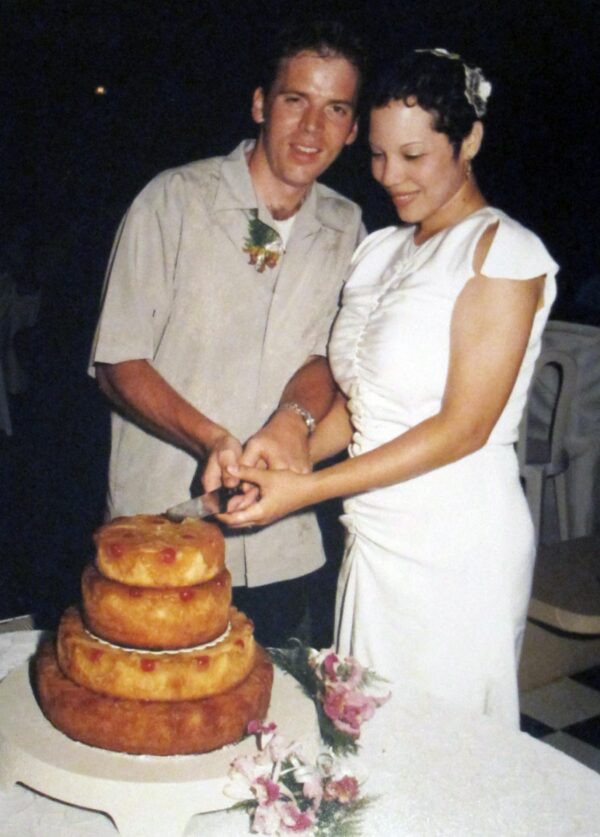 A couple cuts a tiered upside down pineapple cake
