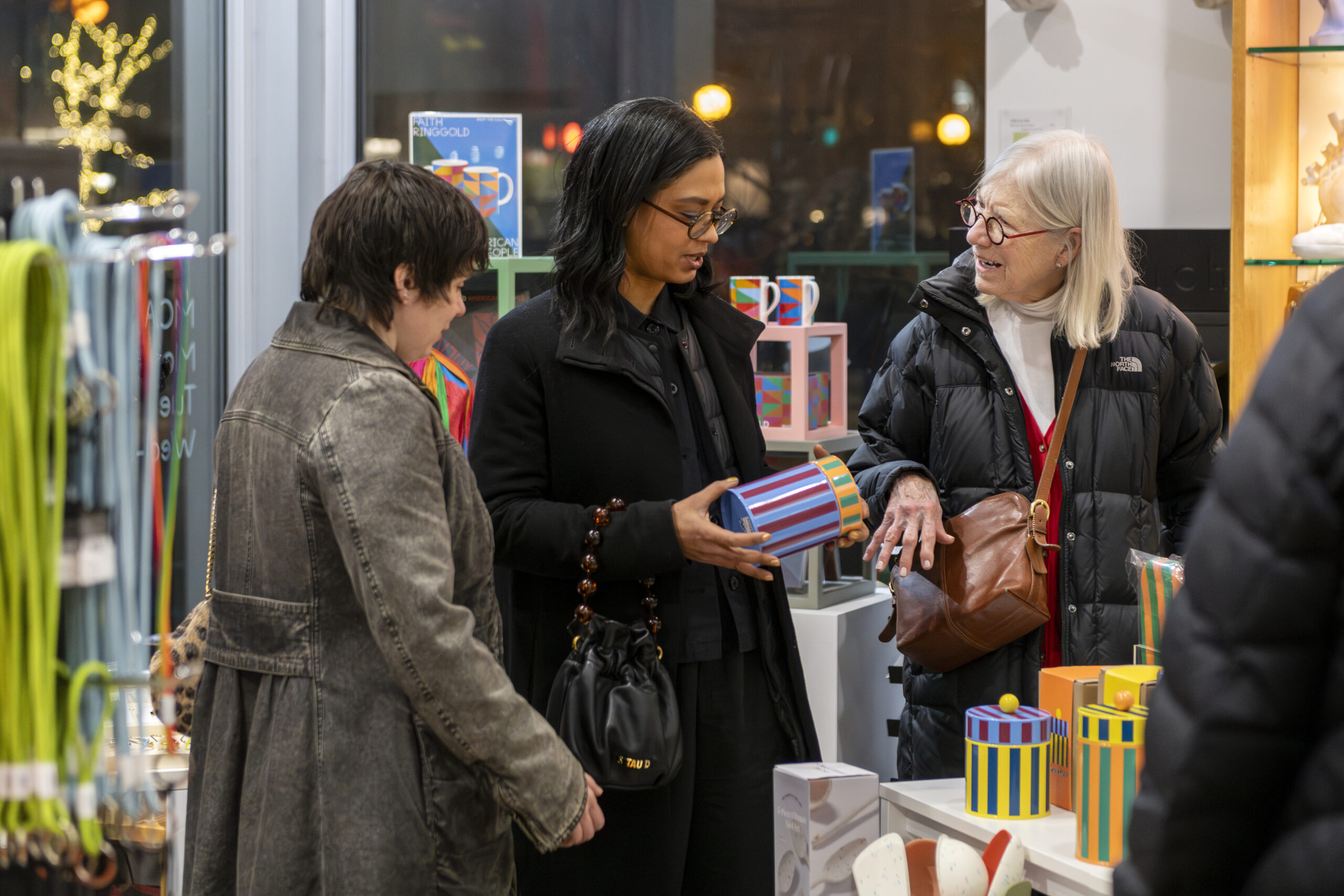 Three people shopping at an a store filled with colorful objects