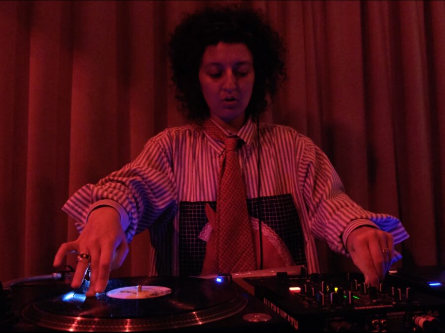 Red toned image of a person spinning records