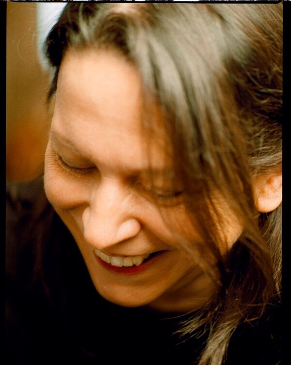 Close up of a person with ash blond air looking down while laughing