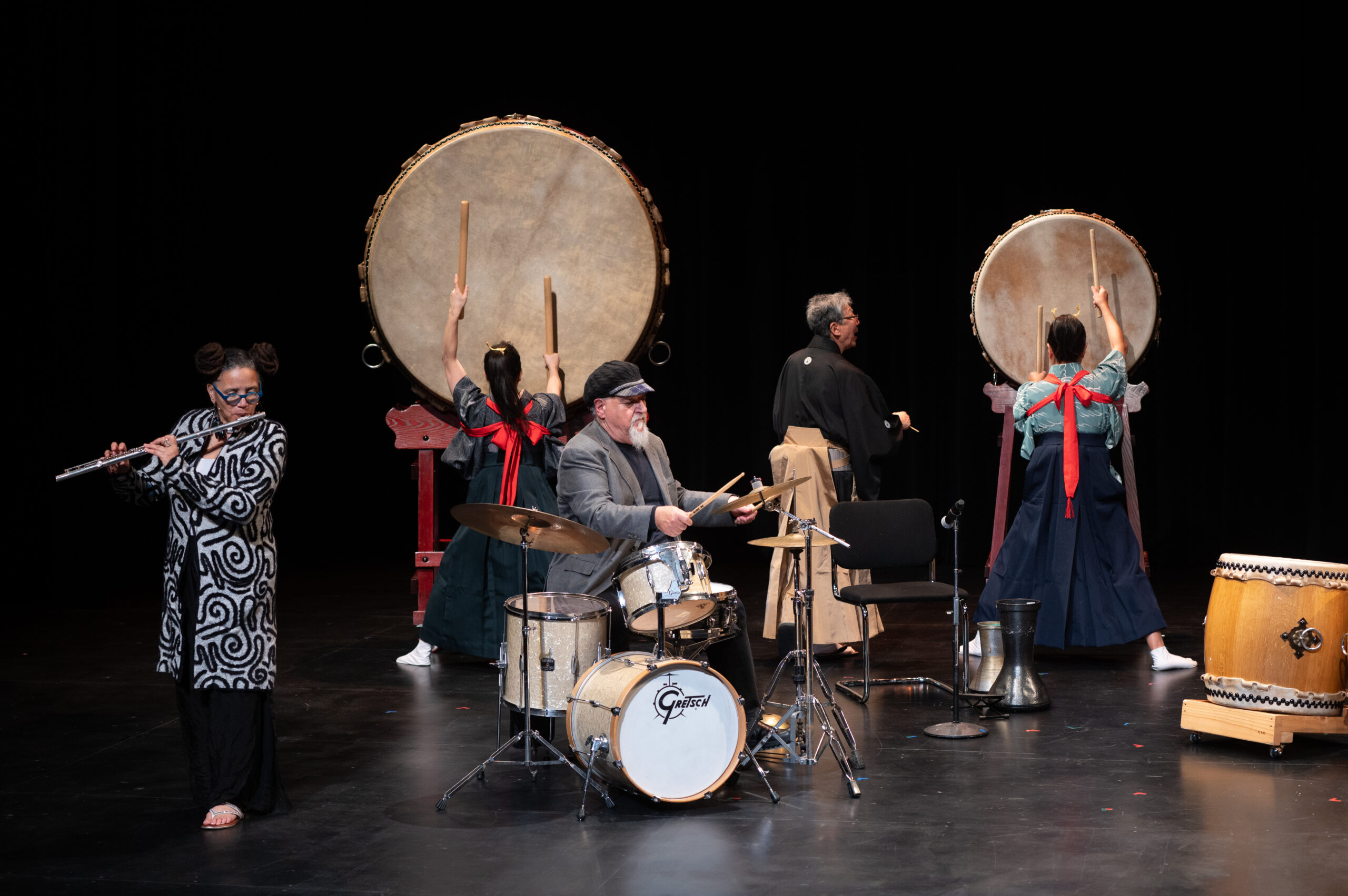 A group of performers play various percussion instruments