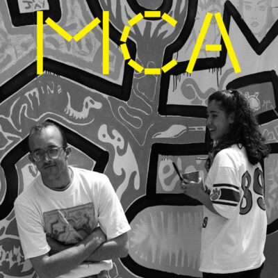 Cover of the MCA fall 2018 members' magazine featuring an archival image of Keith Haring with a teenager in front of a giant mural of his artwork