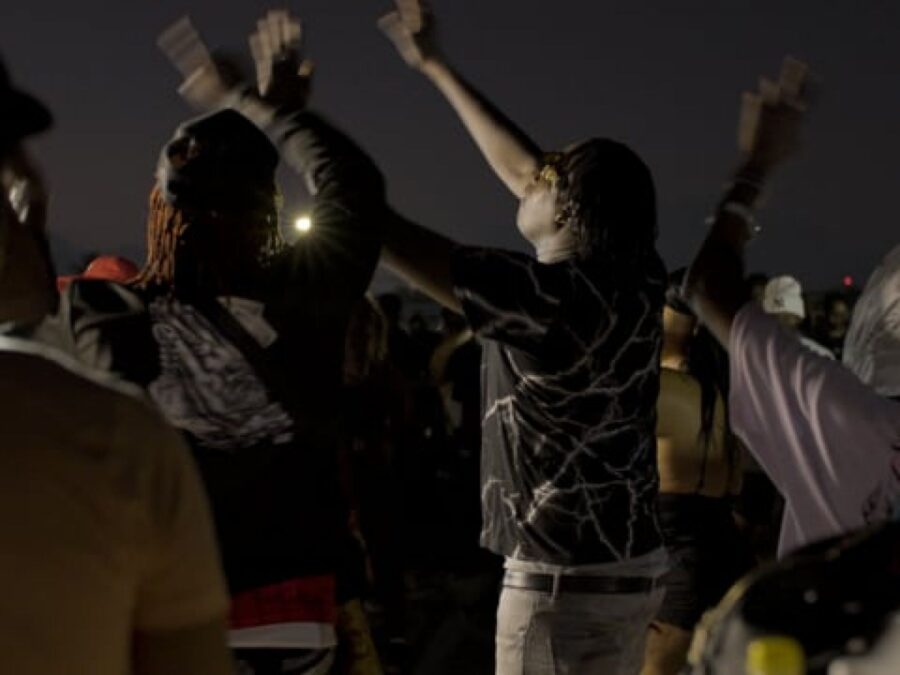 A crowd dancing in a dark space