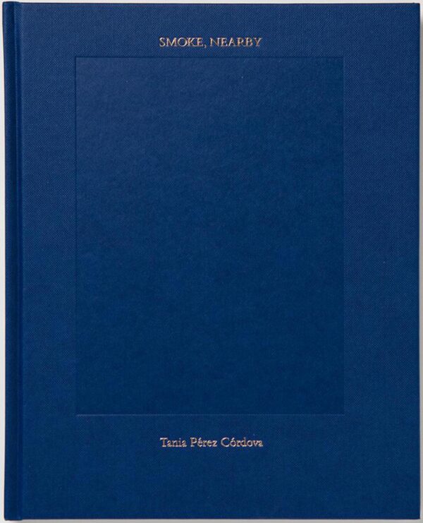 A blue book cover with a debossed vertical rectangle in the middle. Small gold font reads Smoke nearby above it; and Tania Perez Cordova below.