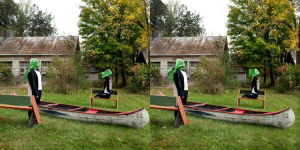 A stereograph depicting two people with green bandanas covering their heads. One person is standing next to a canoe holding a piece of wood. The other is sitting on a bench in the background. The setting is a yard near an abandoned building during the day.