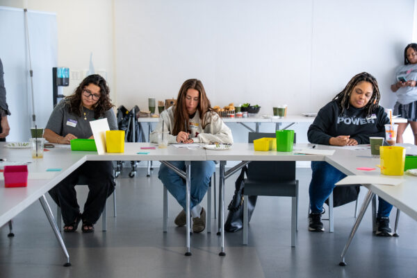 A group of people sitting at a table working on individual projects