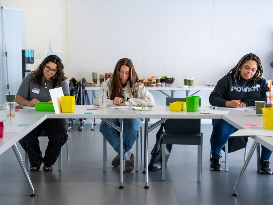 A group of people sitting at a table working on individual projects