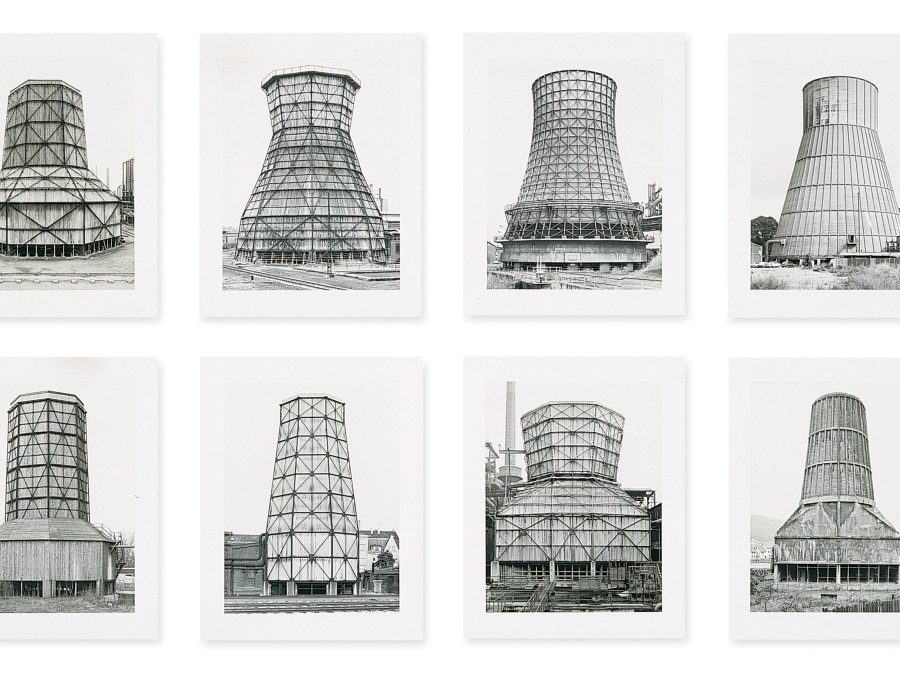 Black-and-white photographs of twelve cooling towers hung in two horizontal rows