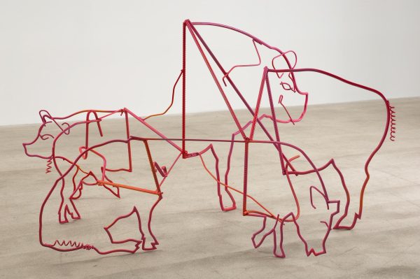 An abstract sculpture depicts five overlapping red pigs.