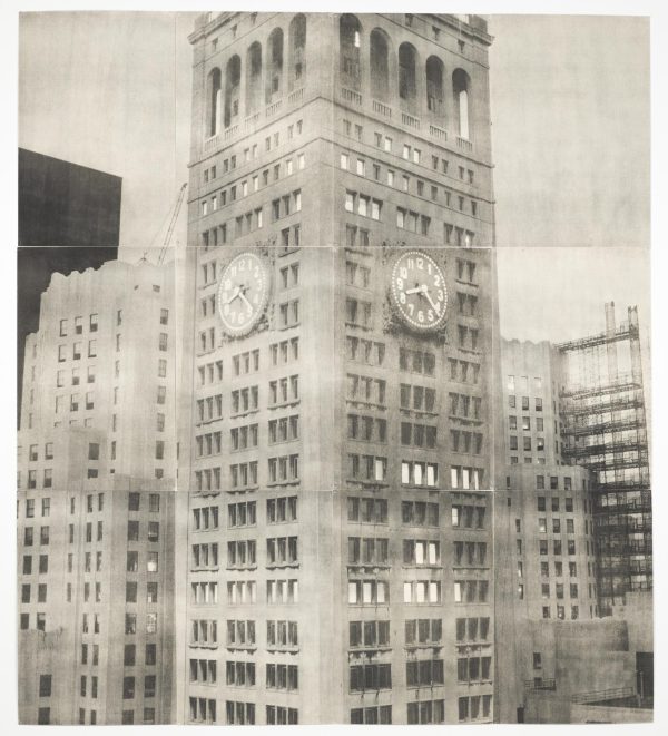 A black-and-white photo shows a clock tower among city buildings.