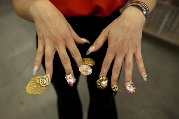 A close up of a person's hands with nails that have been bejeweled